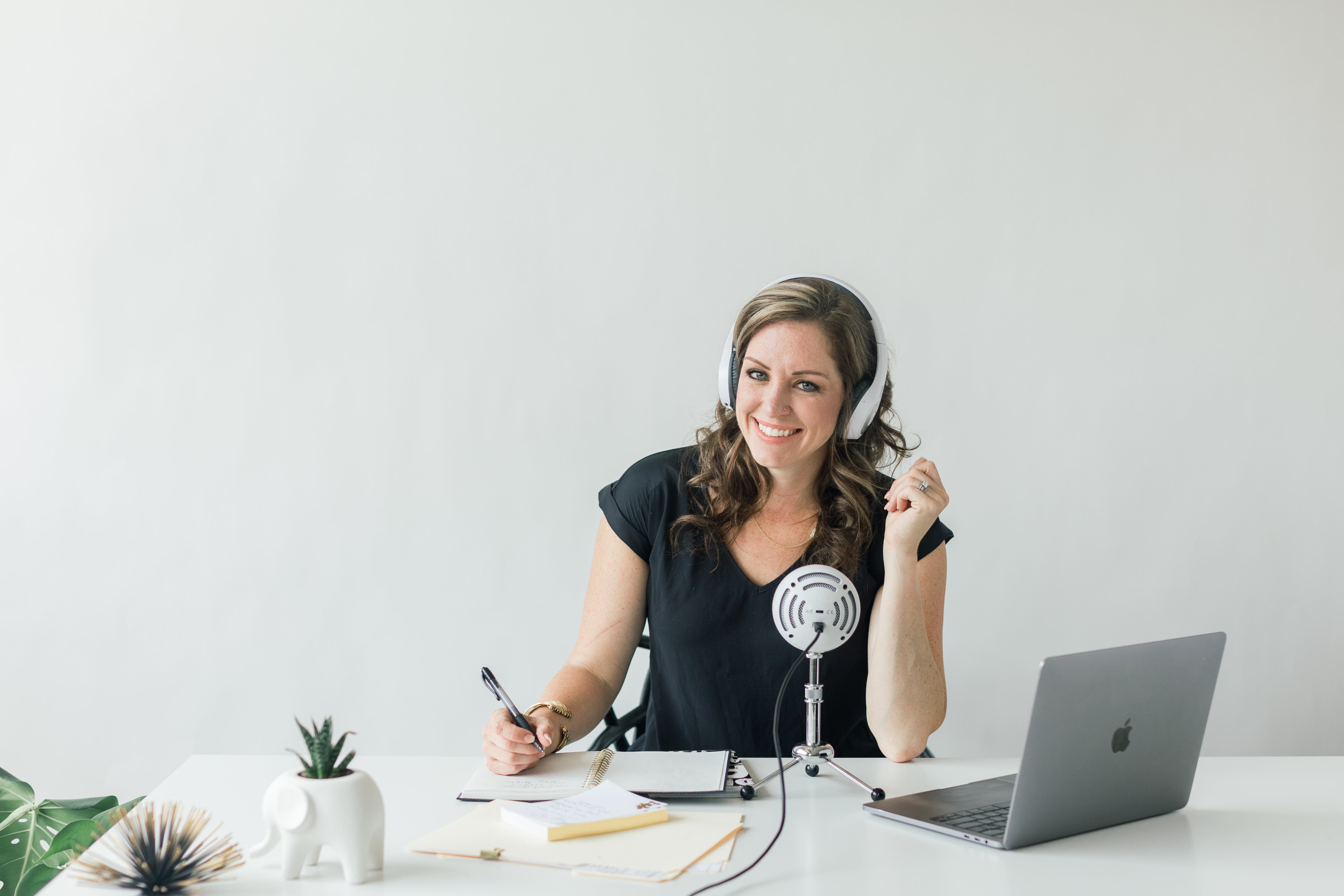 Photography Lawyer Rachel Brenke working at her desk with macbook and podcast setup