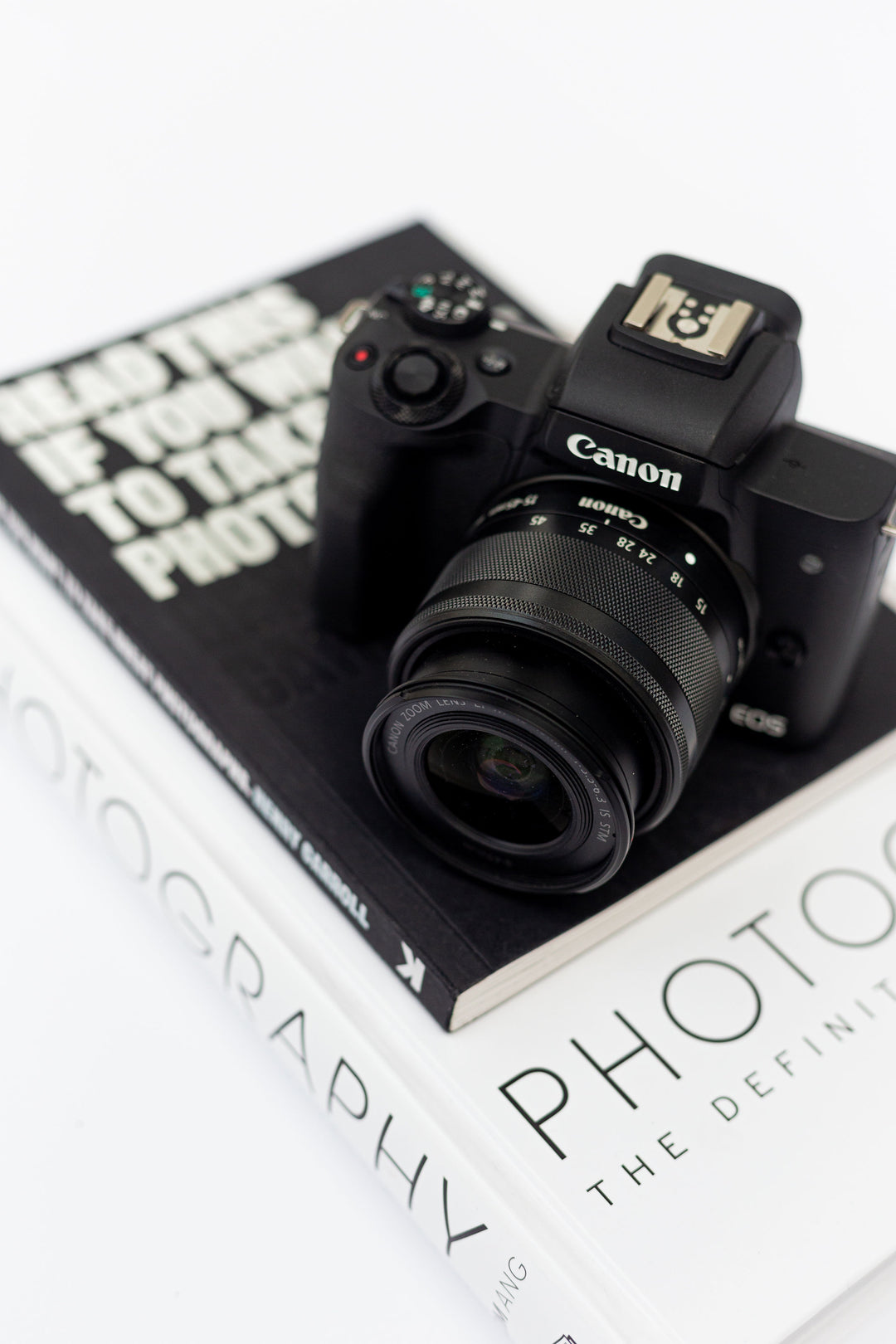 Canon camera sitting on top of photography books