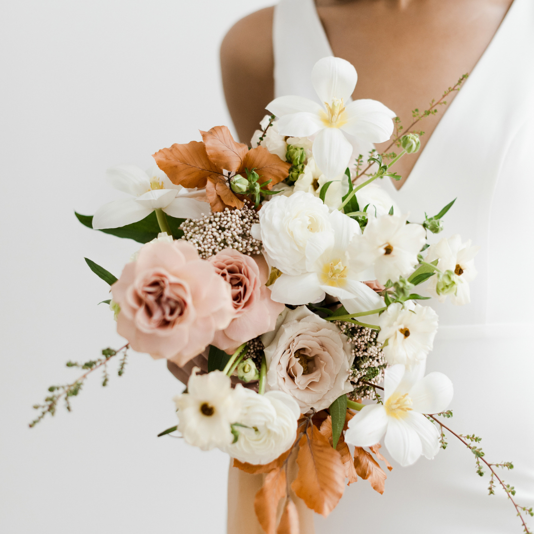 Beautiful wedding bouquet in front of bride in dress